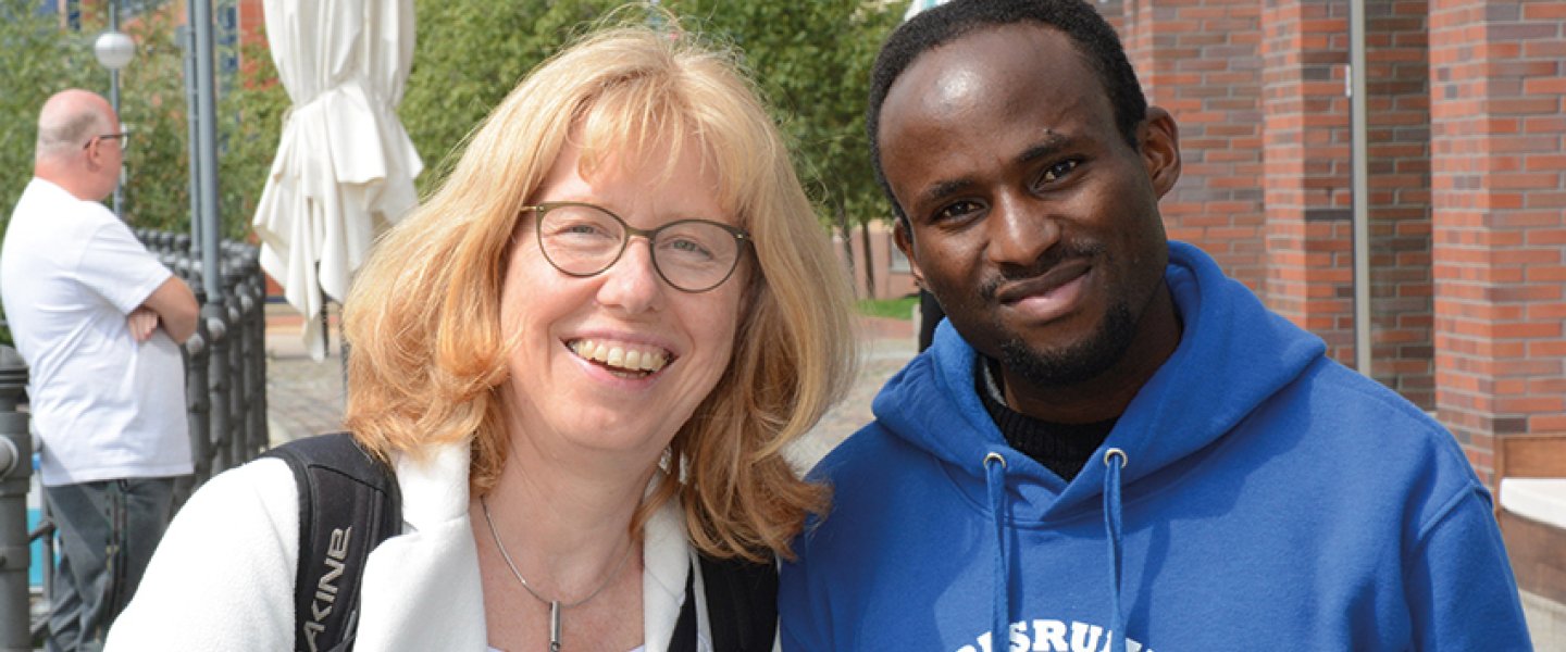 George William Ndiabarema mit Beate Neuenhofer lächeln gemeinsam in die Kamera